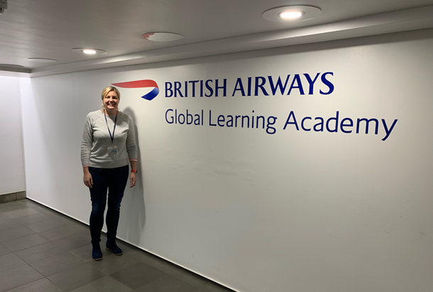 Woman standing in front of British Airways sign